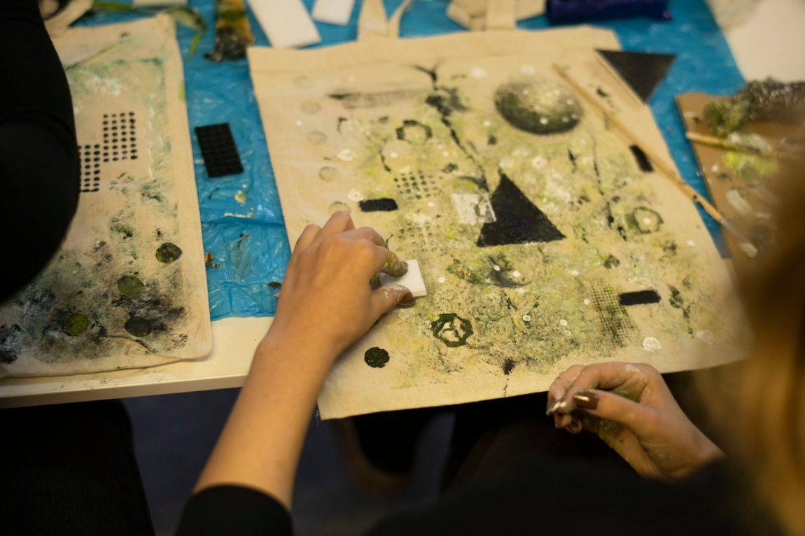 Hands working with printmaking materials and geometric printing blocks